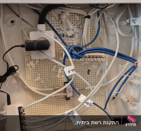 ארון תקשורת ביתי פתוח עם כבלי רשת ונקודות חיבור
